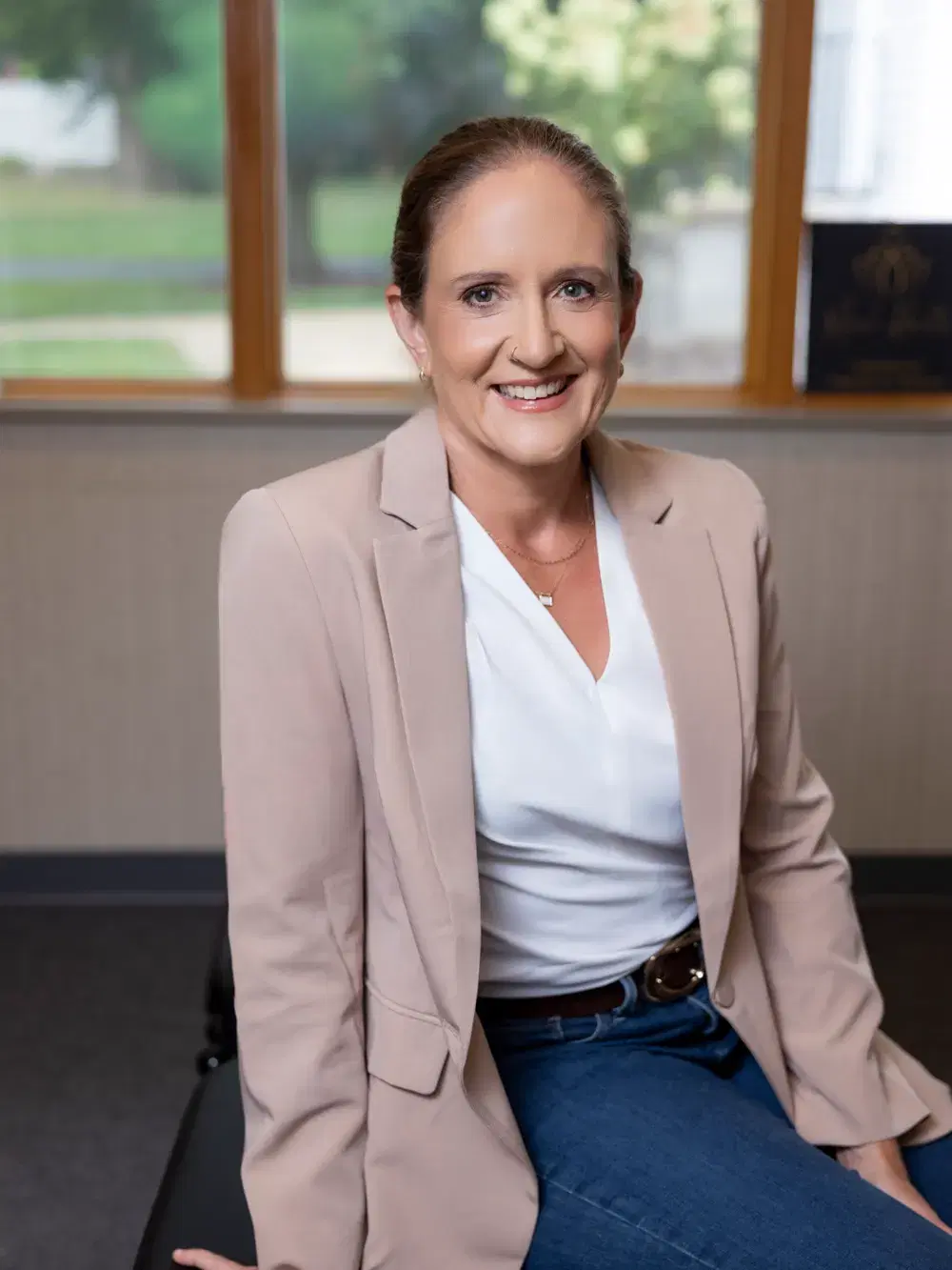 Dr. Jennifer Morrow seated on a treatment table in her office at Mend Health